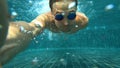 A young white handsome male doing an underwater selfie on an action camera. Portrait of a young man with glasses taking Royalty Free Stock Photo
