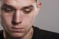 Young white man looking down, close up