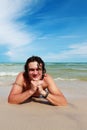 A young white man, lying on a sandy beach. Royalty Free Stock Photo