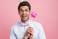 Young white man wearing party cone posing with flower wind spinner