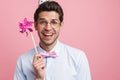 Young white man wearing party cone posing with flower wind spinner