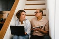 Young white man and woman using tablet computer and laptop in office Royalty Free Stock Photo