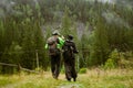 Young people wearing trekking equipment hiking in mountain forest