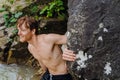 Young ginger man standing by rocks while traveling in nature