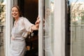 Young waitress woman wearing apron smiling while working in cafe