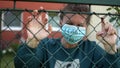 Young white woman behind bars with the inscription on the mask. I cant breathe. Knocks on the fence, aggression look