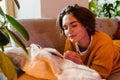 Young white woman reading book while lying on couch Royalty Free Stock Photo