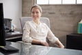 Young white woman sitting at office desk smiling to camera Royalty Free Stock Photo