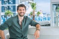 Young wide smiling happy man model portrait in outdoor beach bar Royalty Free Stock Photo