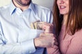 Young wife pulls out dollar bills from her husband`s shirt pocket, the husband grabbed her hand and does not allow to pull out th