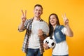 Young win couple, woman man, football fans holding bundle of dollars, cash money, soccer ball, cheer up support team