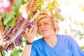 Young winemaker in straw hat examining grapes