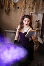 A young witch with a book in her hands cooks a potion in a large black cauldron, emitting magical purple smoke