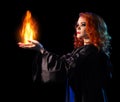 Young witch girl holds fire isolated Royalty Free Stock Photo