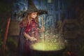 Young witch stirring cauldron Royalty Free Stock Photo