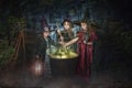 Young witches stirring cauldron Royalty Free Stock Photo