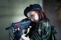 A young woman in an abandoned building with a gun. Laser sight on the machine. Aiming from the machine with a laser. The girl in