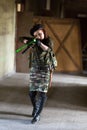 A young woman in an abandoned building with a gun. Laser sight on the machine. Aiming from the machine with a laser. The girl in