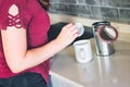 A young woman adding a teabag to a mug in a modern domestic kitchen Royalty Free Stock Photo