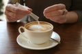 Young woman adding sugar to delicious coffee