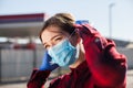 Young woman adjusting protective face mask