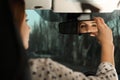 Young woman adjusting rear view mirror in car Royalty Free Stock Photo