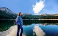 Young woman admires beautiful panorama of Black Lake ( Crno jezero),Durmitor, Montenegro Royalty Free Stock Photo