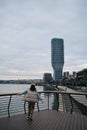 A young woman admires the views in the modern Waterfront area, near the Sava River embankment. View from the ground in a Royalty Free Stock Photo