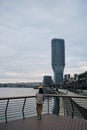 A young woman admires the views in the modern Waterfront area, near the Sava River embankment. View from the ground in a Royalty Free Stock Photo