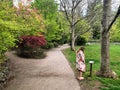 A young woman admiring the beautiful flowers and trees of a park in downtown Ashland during the shakespeare festival