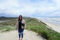 A young woman admiring the Beautiful views of the oregon coast with it`s vast sandy beaches and endless sandy dunes Royalty Free Stock Photo