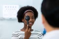 Young woman african american using occluder for eye test ophthalmological in optics clinic. woman checkup eye health with