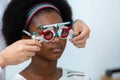 Young woman african american wear trial frame eye test ophthalmological in optics clinic. woman checkup eye health with equipment