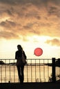 Young woman against clouds