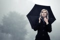 Young fashion woman in black classic coat with umbrella