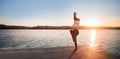 Young woman against sunset and lake water Royalty Free Stock Photo