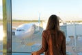 Young woman in the airport looking through the window at airplanes Royalty Free Stock Photo