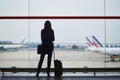 Young woman in the airport, looking through the window at planes Royalty Free Stock Photo