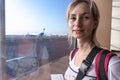 Young woman in the airport, looking through the window at planes. Royalty Free Stock Photo