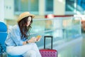 Young woman in an airport lounge waiting for flight aircraft. Caucasian woman with smartphone in the waiting room Royalty Free Stock Photo