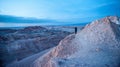 Young woman alone watching sunrise at Valle de la Luna Moon Valley, San Pedro de Atacama Chile. Wide view of stunning sun rise on Royalty Free Stock Photo