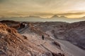 Young woman alone watching sunrise at Valle de la Luna Moon Valley, San Pedro de Atacama Chile. Wide view of stunning sun rise on Royalty Free Stock Photo