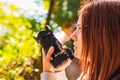 young woman amateur photographer, taking pictures of a mountain landscape. young redhead photographing wildlife. trip. Royalty Free Stock Photo