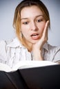 Young woman amazed by what she is reading