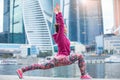 Young woman in anjaneyasana pose against the skyscrapers Royalty Free Stock Photo