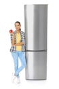 Young woman with apple near closed refrigerator