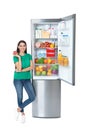 Young woman with apple near open refrigerator