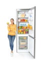 Young woman with apple near open refrigerator