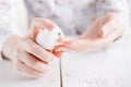 Young woman applies cream on her hands. On a white background