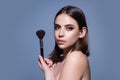 Young woman applies powder on the face using makeup brush. Beautiful girl doing contouring apply blush on cheeks. Face Royalty Free Stock Photo